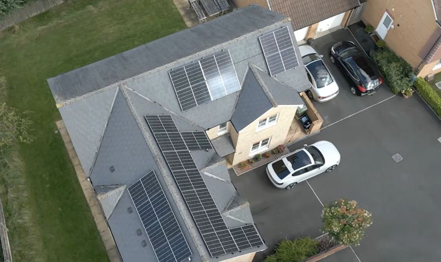 Top-down drone photo of a house roof with solar panels